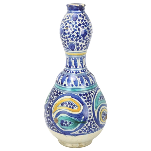 176 - A Middle Eastern pottery double-gourd vase, with blue painted decoration, height 29cm