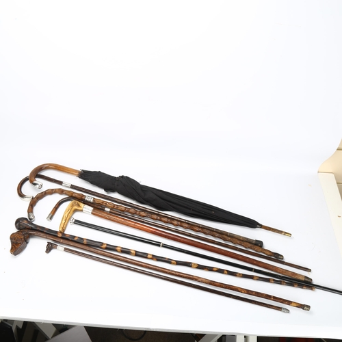 186 - A group of various walking sticks and umbrellas, including some silver-mounted