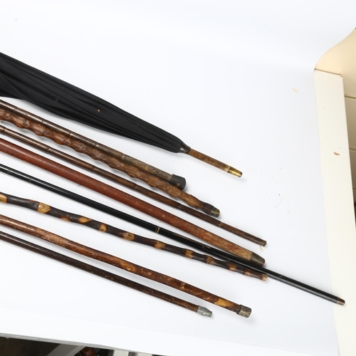 186 - A group of various walking sticks and umbrellas, including some silver-mounted