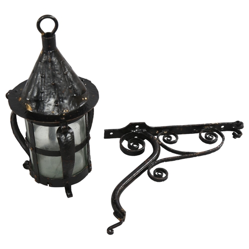 209 - An Arts and Crafts style blackened metal planished storm lantern with scrolled bracket, height 28cm