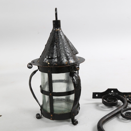 209 - An Arts and Crafts style blackened metal planished storm lantern with scrolled bracket, height 28cm