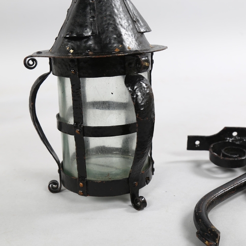 209 - An Arts and Crafts style blackened metal planished storm lantern with scrolled bracket, height 28cm