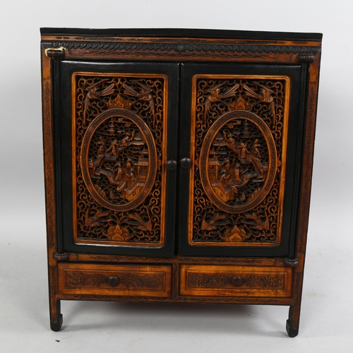 214 - An early 20th century Chinese table-top cabinet, with relief carved panels, ebonised pine constructi... 