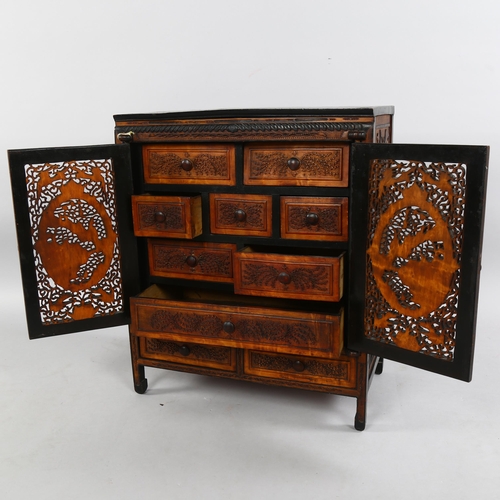 214 - An early 20th century Chinese table-top cabinet, with relief carved panels, ebonised pine constructi... 