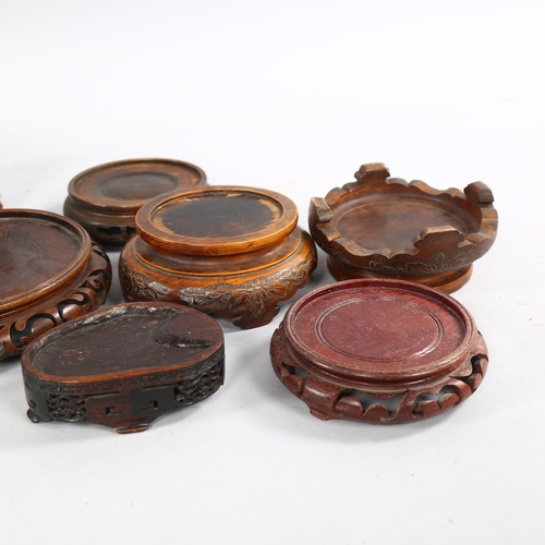 218 - A collection of 8 Chinese hardwood stands, all with carving to edges