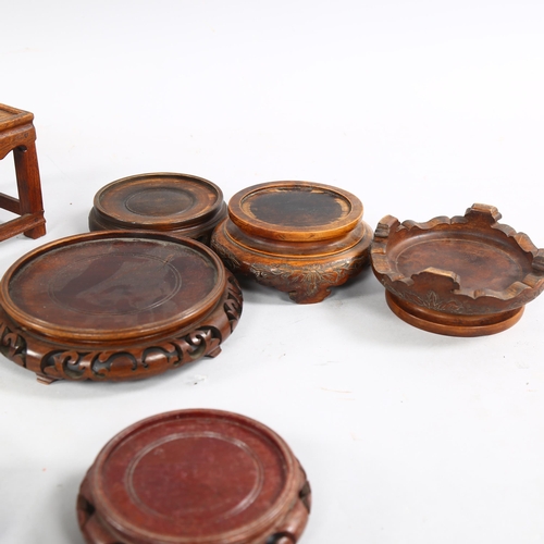 218 - A collection of 8 Chinese hardwood stands, all with carving to edges