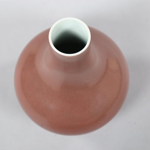 225 - A peach glaze narrow-neck vase, with character marks to base, height 19cm