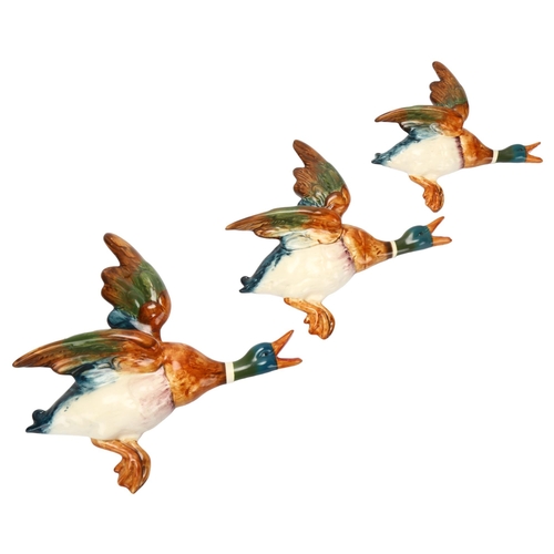 52 - Graduated set of 2 Beswick flying duck wall ornaments, pattern no. 596, largest length 25cm