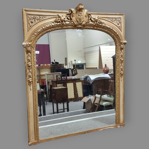 75 - A large 19th century ornate carved giltwood framed wall mirror, with carved and scrolled shield pedi... 