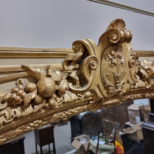 75 - A large 19th century ornate carved giltwood framed wall mirror, with carved and scrolled shield pedi... 