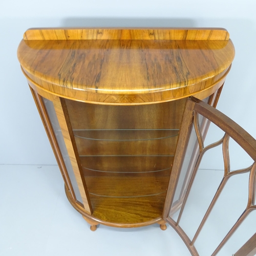 2005 - A 1930s walnut bow-front display cabinet, with three fitted glass shelves and raised on cabriole leg... 