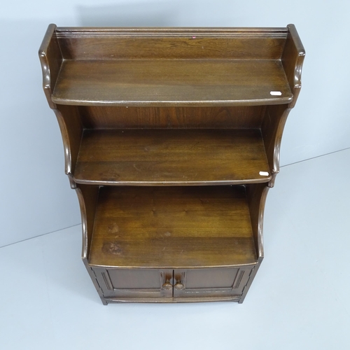 2007 - An Ercol waterfall open bookcase, with cupboards to base. 62x110x36cm.