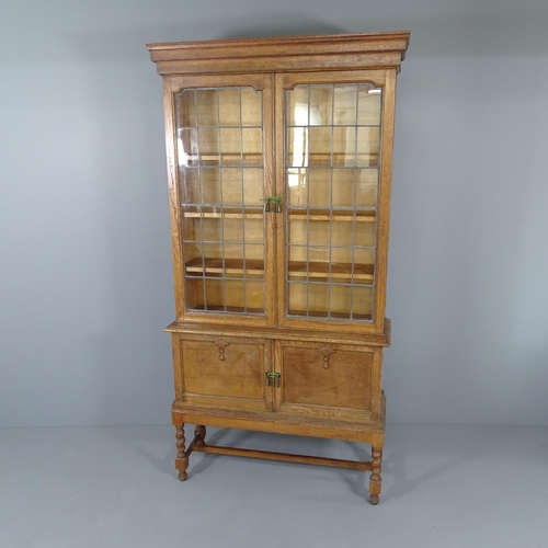 2012 - An early 20th century oak bookcase on stand, with two leadlight glazed doors, three fixed shelves an... 