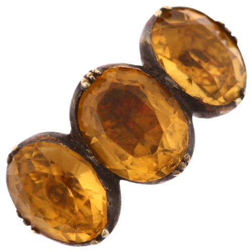 1121 - A Georgian three stone citrine ring, unmarked gold closed back settings set with oval mixed-cut citr... 