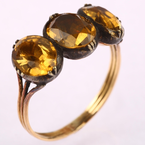 1121 - A Georgian three stone citrine ring, unmarked gold closed back settings set with oval mixed-cut citr... 