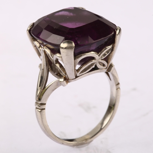 1143 - A large late 20th century amethyst dress ring, unmarked white metal settings, set with oval mixed-cu... 