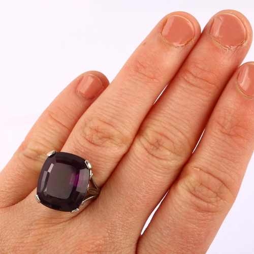 1143 - A large late 20th century amethyst dress ring, unmarked white metal settings, set with oval mixed-cu... 