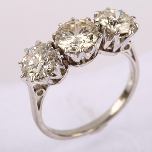 1146 - A three stone diamond ring, claw set with modern round brilliant-cut diamonds, total diamond content... 