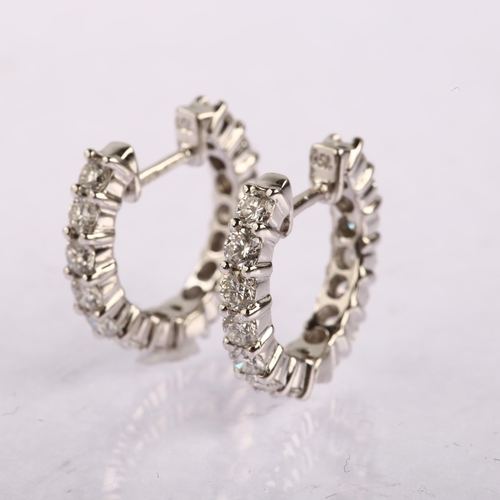 1147 - A pair of 18ct white gold diamond hoop earrings, set with modern round brilliant-cut diamonds, total... 