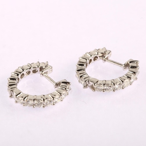 1147 - A pair of 18ct white gold diamond hoop earrings, set with modern round brilliant-cut diamonds, total... 