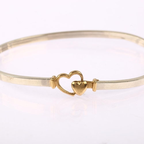 1168 - A modern 9ct yellow and white gold heart torque bangle, band width 2.8mm, internal circumference 17.... 