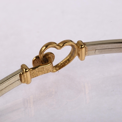 1168 - A modern 9ct yellow and white gold heart torque bangle, band width 2.8mm, internal circumference 17.... 