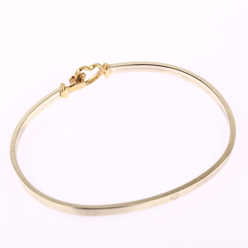 1168 - A modern 9ct yellow and white gold heart torque bangle, band width 2.8mm, internal circumference 17.... 