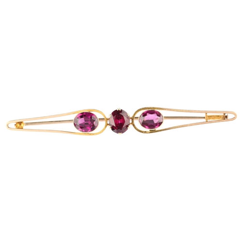 1186 - A large early 20th century three stone amethyst openwork bar brooch, unmarked gold settings with ova... 