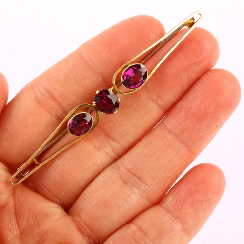 1186 - A large early 20th century three stone amethyst openwork bar brooch, unmarked gold settings with ova... 