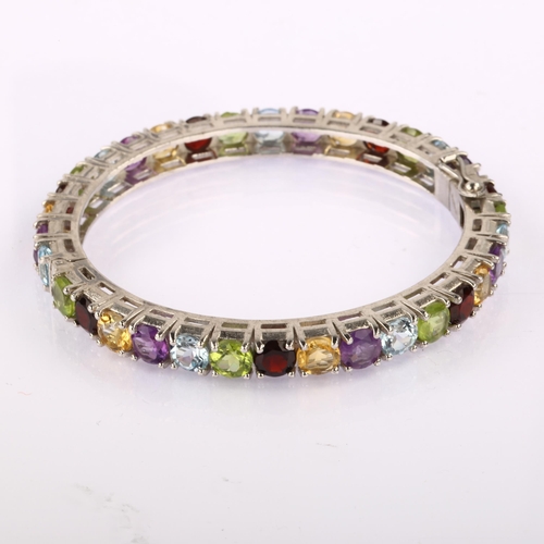 1348 - A modern Continental silver gem set hinged bangle, gemstones include garnet amethyst peridot citrine... 