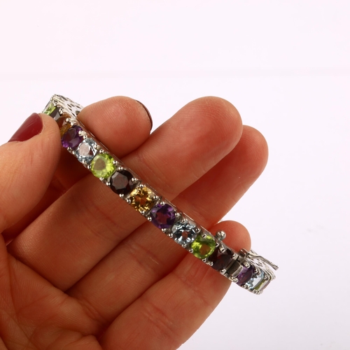 1348 - A modern Continental silver gem set hinged bangle, gemstones include garnet amethyst peridot citrine... 