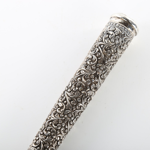 1458 - An early 20th century Indian silver parasol handle, allover relief embossed foliate decoration, leng... 