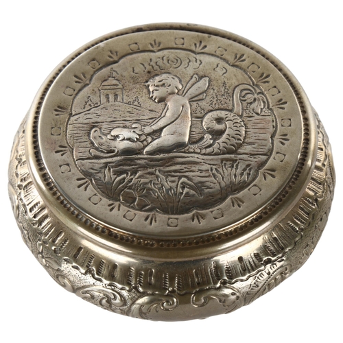 1462 - A German silver circular box, relief embossed cherub riding water dragon and foliate decoration, mar... 