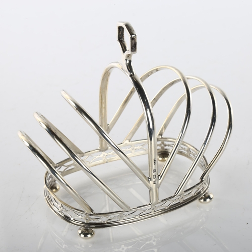 1488 - An Art Deco George V silver 7-bar toast rack, crown form with pierced gallery and bun feet, by Docke... 