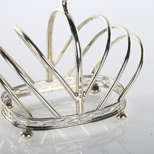 1488 - An Art Deco George V silver 7-bar toast rack, crown form with pierced gallery and bun feet, by Docke... 