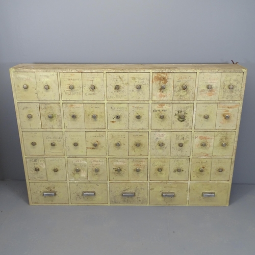 2500 - A vintage painted pine bank of 45 drawers. 161x110x24cm.