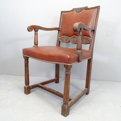 2510 - An antique carved oak and studded leather upholstered open arm desk chair.