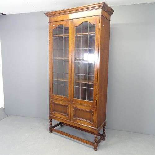 2519 - A large Edwardian oak geometric display bookcase, with two leadlight glazed doors revealing three ad... 