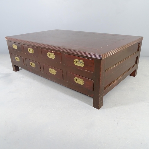 2557 - A hardwood rectangular low coffee table, both sides fitted with eight drawers with campaign style br... 