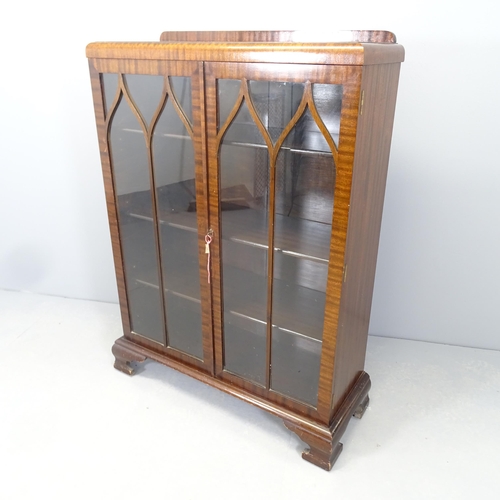 2567 - A 1930s style two door bookcase, with raised back and three adjustable shelves. 90x120x34cm. With ke... 