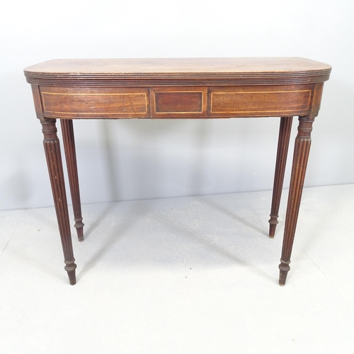 2568 - An antique mahogany and satinwood strung fold-over tea table, raised on fluted legs. 91x74x45cm