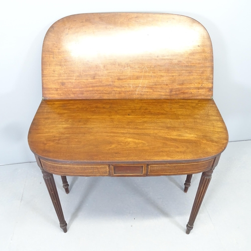 2568 - An antique mahogany and satinwood strung fold-over tea table, raised on fluted legs. 91x74x45cm