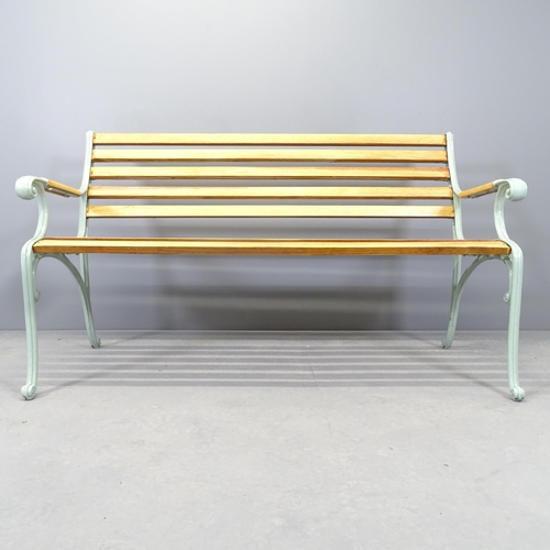 2574 - A pine slatted garden bench with cast iron ends. 144x84x66cm