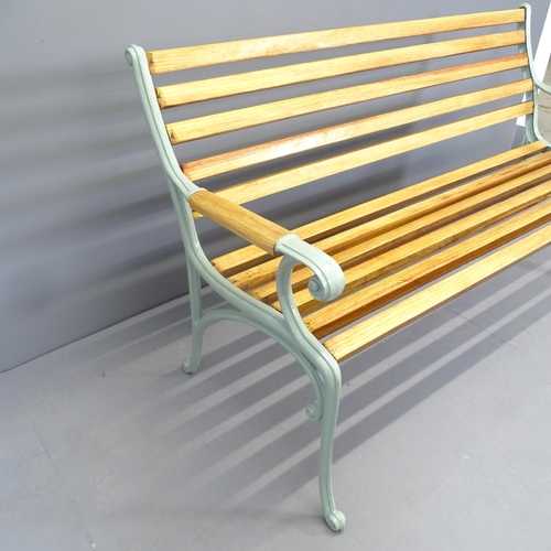 2574 - A pine slatted garden bench with cast iron ends. 144x84x66cm