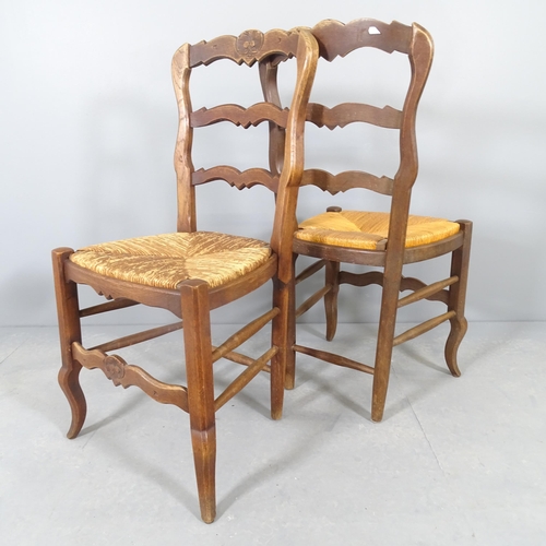 2580 - A set of four French oak rush-seated ladderback dining chairs. WITH THE OPTION TO PURCHASE THE FOLLO... 