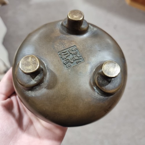 194 - A Chinese patinated bronze censer, of circular form with loop handles, the carved and pierced wooden... 