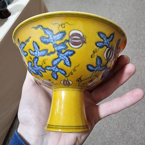 220 - A yellow Chinese stem bowl with blue under-glaze decoration, character marks inside base, height 10.... 