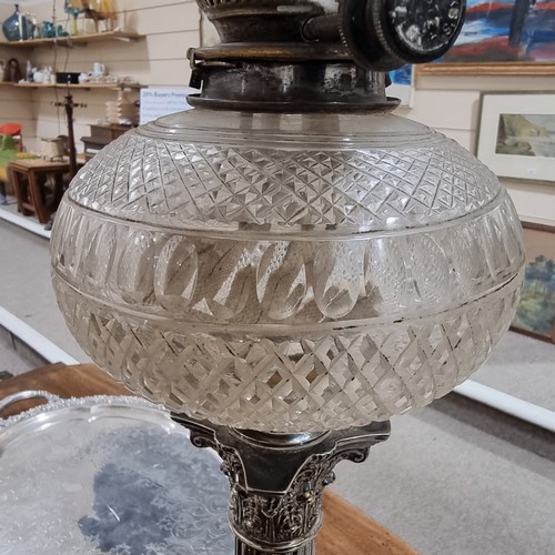 208 - A late 19th century silver plated Corinthian column oil lamp with cut-glass well, with later shade a... 