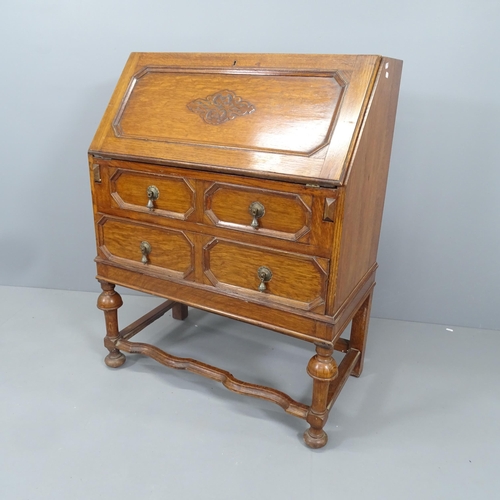 2135 - A 1920s oak bureau, the fall-front revealing a fitted interior with two long drawers below. 82x99x45... 