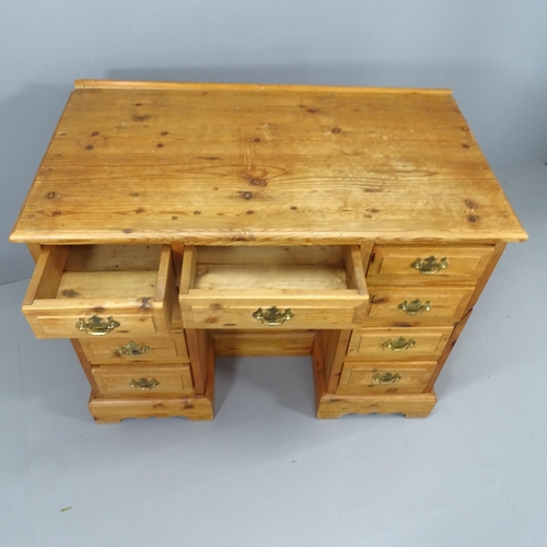 2138 - A modern pine kneehole desk, with nine drawers and recessed cupboard. Overall 101x78x56cm, kneehole ... 